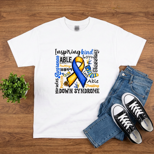 White Down Syndrome Awareness blue and yellow ribbon T-shirt flat lay on brown wood with jeans and black sneakers